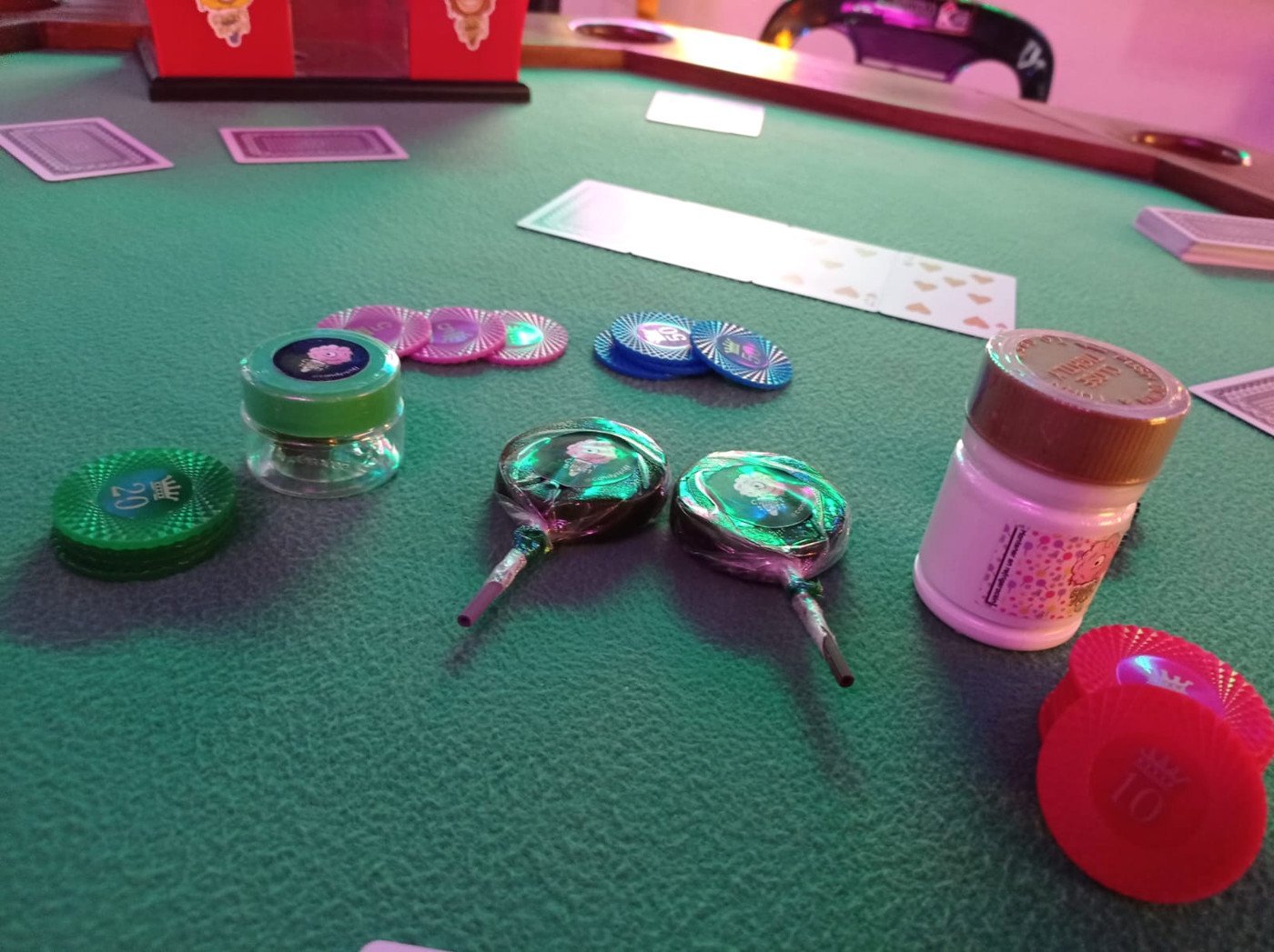 Mesa de juegos de Kif House con cartas, fichas y productos Candy Spliff